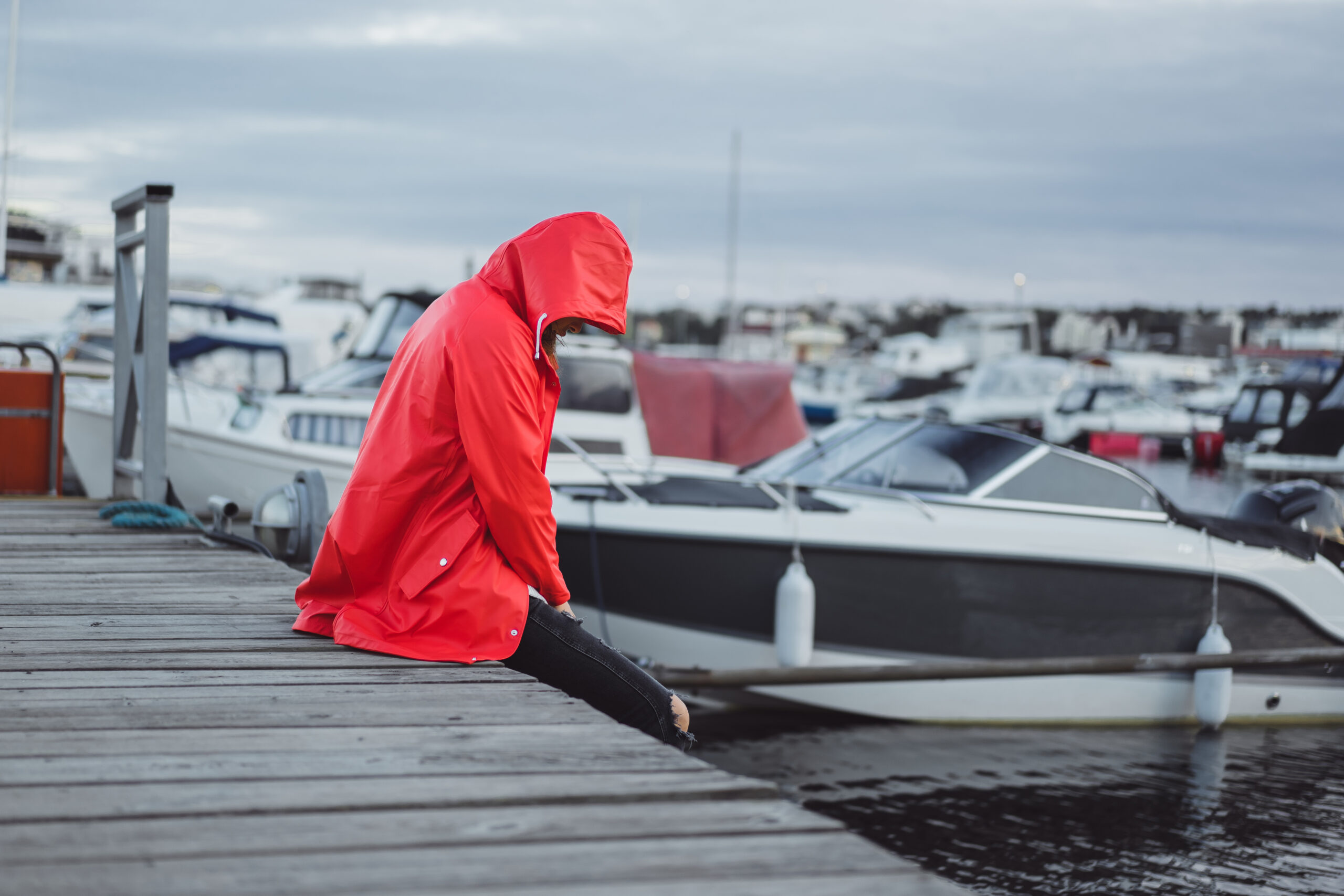 Beautiful young woman in a red cloak in the yacht port. Stockhol