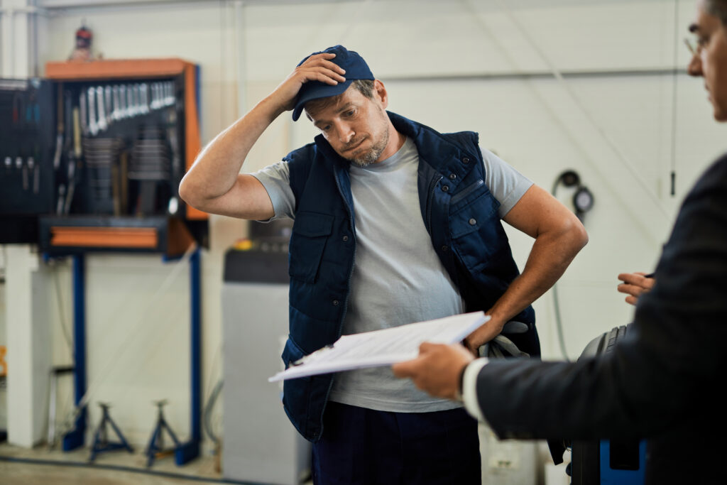 distraught-car-mechanic-going-through-problematic-paperwork-with-his-manager-auto-repair-shop